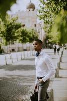 Young African American businessman waitng a taxi on a street photo