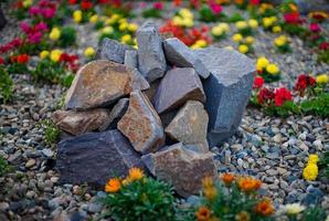 un tobogán de piedras en el fondo de un macizo de flores foto