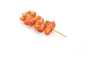 Deep-fried Korean rice cake, or Tteokbokki, skewered with spicy sauce isolated on white background photo