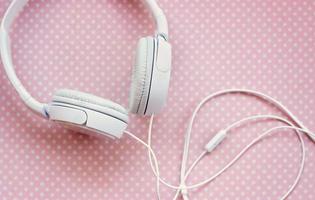 White headphones on pink background photo