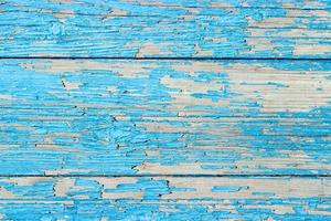 Close up of a old wooden door, teal blue paint peeling off texture background photo
