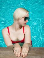 Joven hermosa chica sexy disfrutando de nadar en la piscina privada y relajarse bajo el sol foto