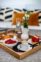 Breakfast in bed. Raspberries, coffee, cake, croissant. Cozy hotel. photo