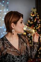 Christmas shooting. Beautiful model with New Year's gifts on background of a Christmas tree. photo