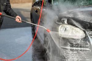 Autoservicio de lavado de autos sin toque. lavar con agua y espuma. foto