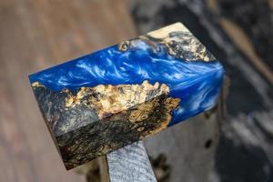 casting epoxy resin Stabilizing burl Afzelia wood blue color abstract art background for blanks photo