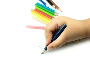 Cerca de la mano de la niña con lápiz escribiendo palabras en inglés a mano