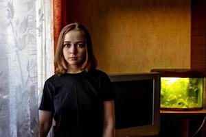Retrato de una joven adolescente en una habitación junto a la ventana por la noche foto