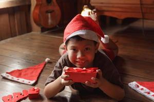 niño con caja de regalo el día de navidad foto