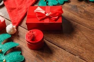Red gift box and santa hat on wooden background photo