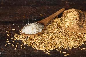 Raw steamed rice and paddy rice on wooden background photo