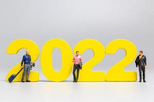 Gente de negocios en miniatura de pie en el número 2022 foto