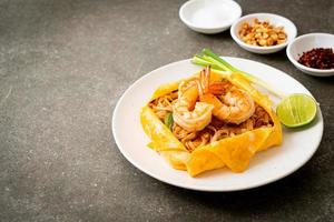 Thai stir fried noodles with shrimps and egg wrap photo