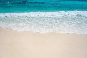 Clear sea waves and white sandy beach in summer. photo