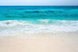 Clear sea waves and white sandy beach in summer. photo
