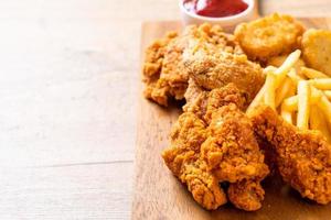 Pollo frito con papas fritas y nuggets de comida - comida chatarra y comida malsana foto