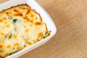 Lasaña de espinacas al horno con queso en placa blanca. foto