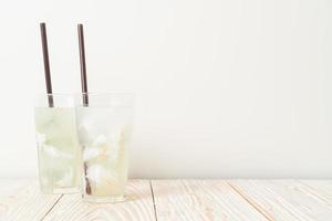 Coconut water or coconut juice in glass with ice cubes photo