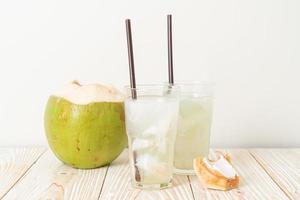 agua de coco o jugo de coco en vaso con cubitos de hielo foto