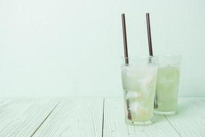 Coconut water or coconut juice in glass with ice cubes photo