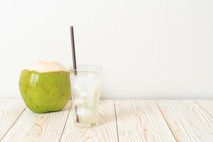 Coconut water or coconut juice in glass with ice cubes photo