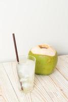 Coconut water or coconut juice in glass with ice cubes photo