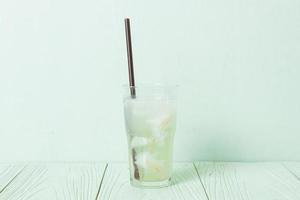 agua de coco o jugo de coco en vaso con cubitos de hielo foto