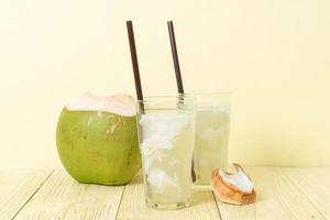 Coconut water or coconut juice in glass with ice cubes photo