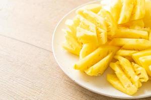 Fresh pineapple sliced on white plate photo