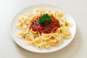 Farfalle pasta in tomato sauce with parsley - Italian food style photo