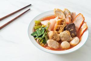 Noodles with meatballs in pink soup or Yen Ta Four Noodles in Asian style photo