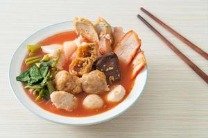 Noodles with meatballs in pink soup or Yen Ta Four Noodles in Asian style photo