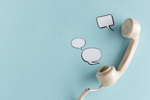 Top view of chat bubbles with telephone receiver and copy space. High quality beautiful photo concept