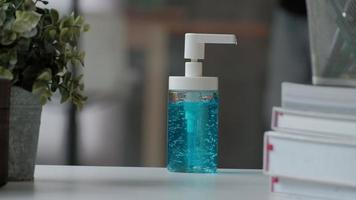 vista frontale e primo piano. uomo casual che preme una bottiglia di gel alcolico, disinfettante per le mani per l'igiene sanitaria per prevenire malattie e batteri come il coronavirus covid-19 mentre si lavora in ufficio. video