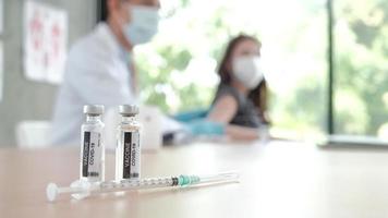manlig läkare som vaccinerar asiatisk kvinna för att skydda covid-19.