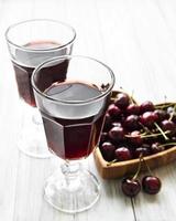 Cherry liqueur in a glass and fresh fruits
