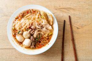 Noodles with pork and meatballs in spicy soup or Tom yum noodles in Asian style photo