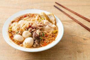 Noodles with pork and meatballs in spicy soup or Tom yum noodles in Asian style photo