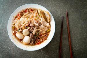 Noodles with pork and meatballs in spicy soup or Tom yum noodles in Asian style photo