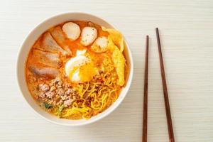 Egg noodles with pork and meatball in spicy soup or Tom Yum Noodles in Asian style photo