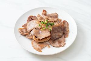 Cuello de cerdo a la parrilla en rodajas en un plato al estilo asiático foto