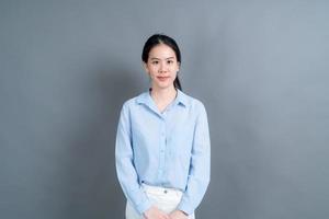 Happy Asian woman with happy face in blue shirt on grey background photo