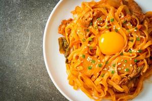 fideos udon salteados con kimchi y cerdo - estilo de comida coreana foto