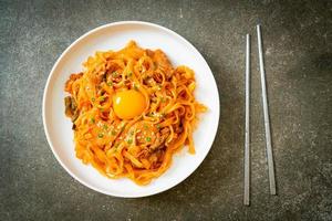 Stir-fried udon noodles with kimchi and pork - Korean food style photo