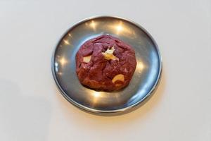 Red velvet cookie with macadamia nut on plate photo