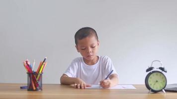 un garçon assis et dessinant video