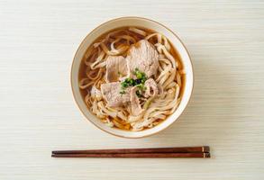 Homemade udon ramen noodles with pork in soy or shoyu soup photo