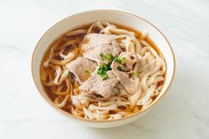 Homemade udon ramen noodles with pork in soy or shoyu soup photo