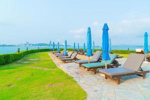 Chair pool and umbrella around swimming pool with ocean sea background photo