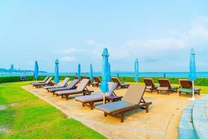 Chair pool and umbrella around swimming pool with ocean sea background photo